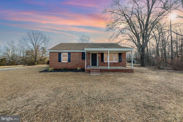 ranch-style home featuring a yard and a porch