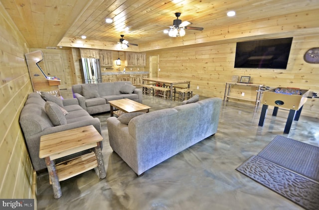 living room featuring concrete flooring, wooden ceiling, ceiling fan, and wood walls