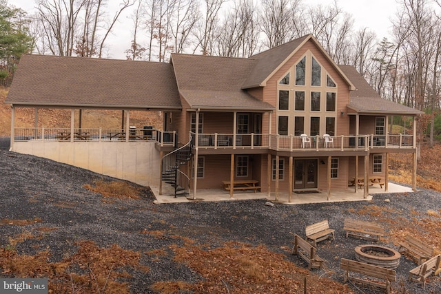 rear view of house with a wooden deck and a patio