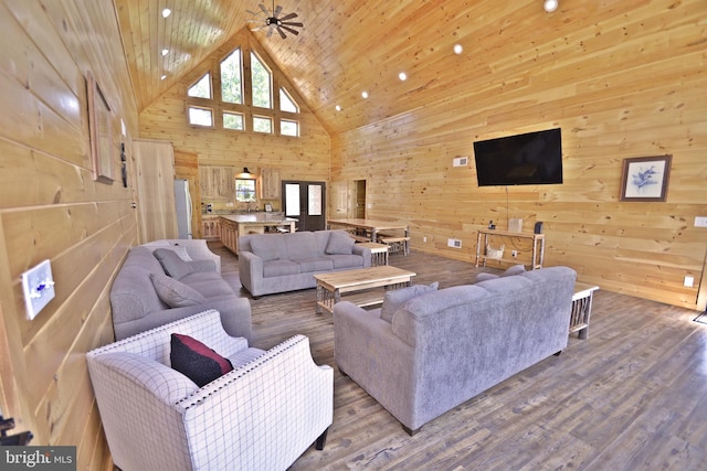 living room featuring wood-type flooring, ceiling fan, wood ceiling, and wood walls