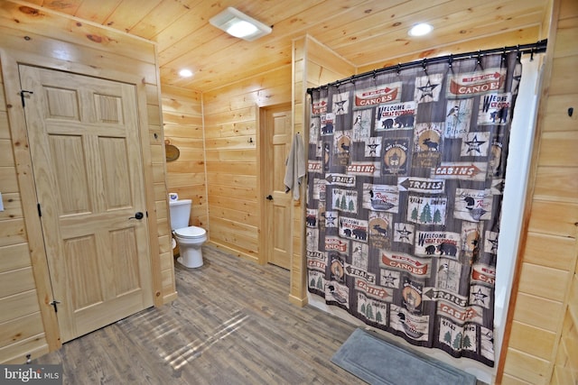 bathroom with wood walls, hardwood / wood-style floors, wooden ceiling, and toilet