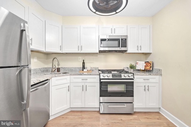 kitchen featuring appliances with stainless steel finishes, sink, and white cabinets