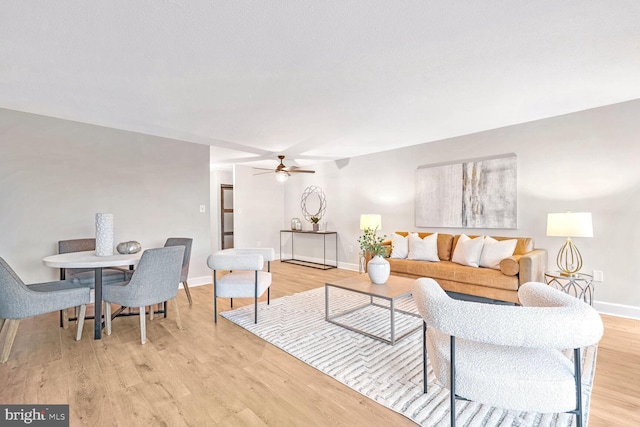 living room featuring light hardwood / wood-style flooring and ceiling fan