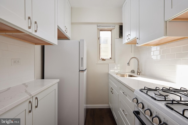 kitchen featuring light stone countertops, white cabinets, and white appliances