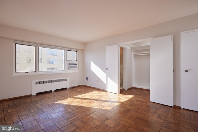 interior space featuring cooling unit, dark parquet flooring, and radiator heating unit