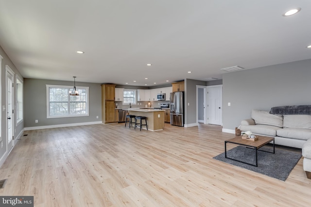 living room featuring an inviting chandelier and light wood-type flooring