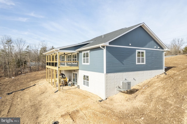 view of property exterior with a sunroom and central air condition unit