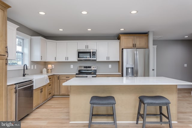 kitchen with sink, a breakfast bar area, stainless steel appliances, and a center island