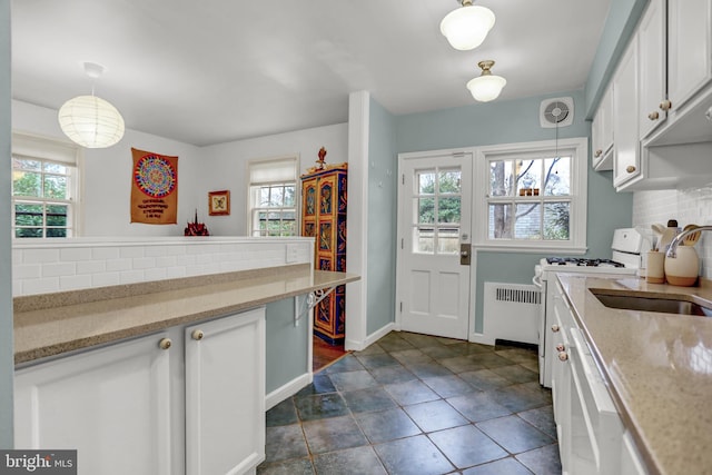 kitchen featuring pendant lighting, white cabinetry, tasteful backsplash, and white range with gas stovetop