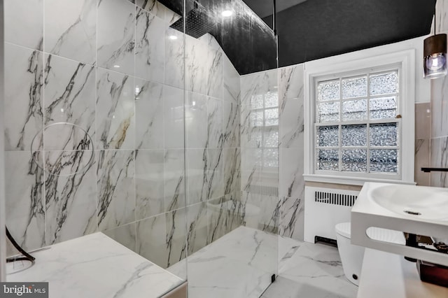 bathroom with radiator heating unit, sink, tile walls, tiled shower, and toilet