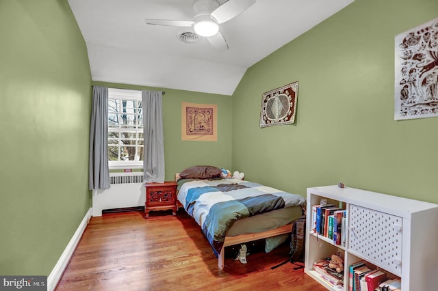 bedroom featuring lofted ceiling, radiator, ceiling fan, and light hardwood / wood-style flooring