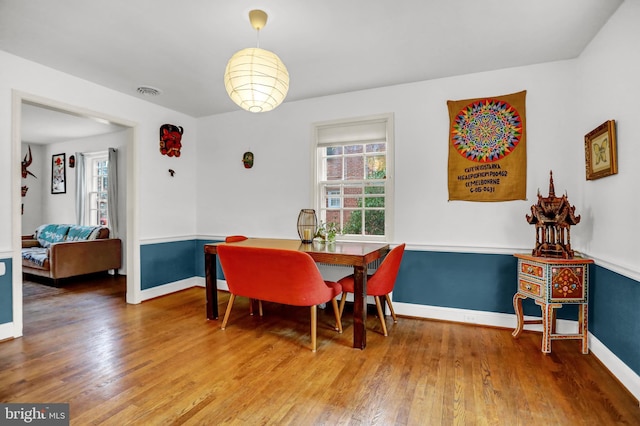 dining space with wood-type flooring and a healthy amount of sunlight