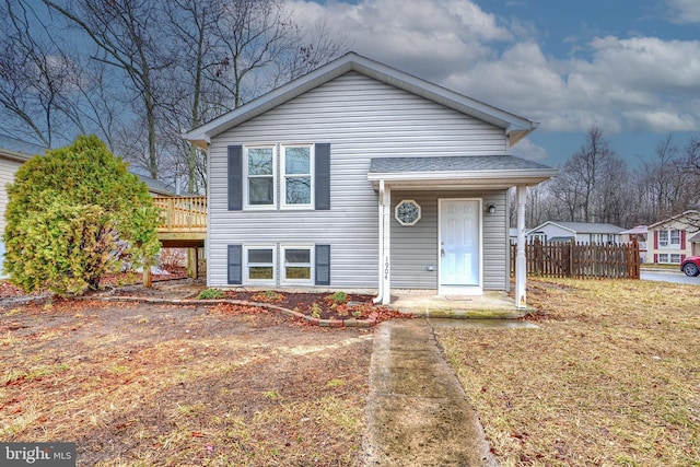 view of front of property featuring a shingled roof, a deck, and fence