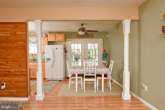 dining space with a ceiling fan, light wood-style flooring, and baseboards