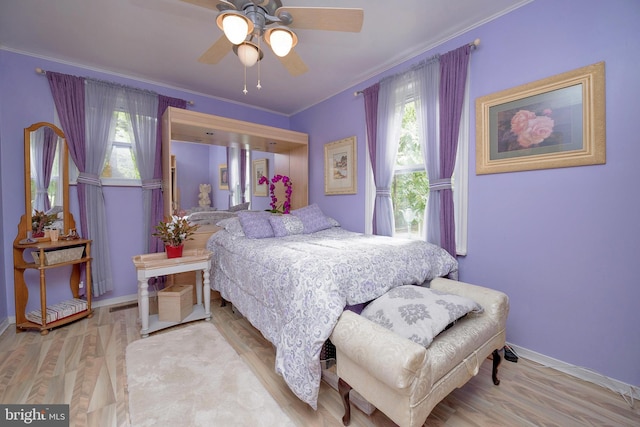 bedroom with ceiling fan, ornamental molding, wood finished floors, and baseboards