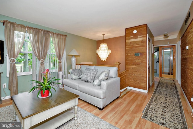 living room with a chandelier, visible vents, and light wood-style flooring