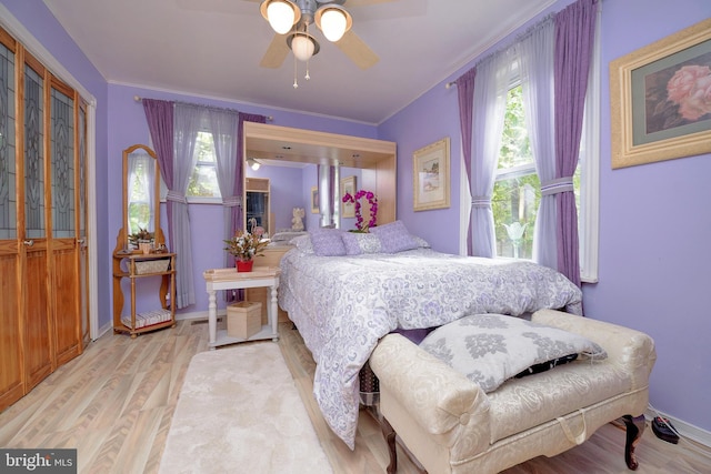 bedroom featuring ceiling fan, baseboards, wood finished floors, and ornamental molding