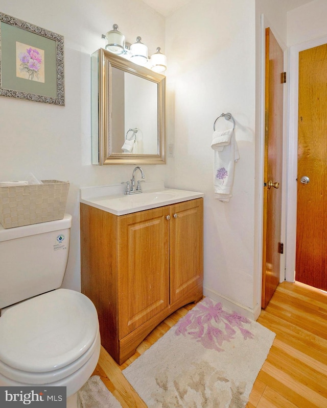 bathroom featuring toilet, wood finished floors, and vanity