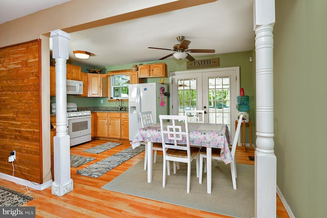 kitchen with white appliances, baseboards, french doors, light wood-style floors, and a sink