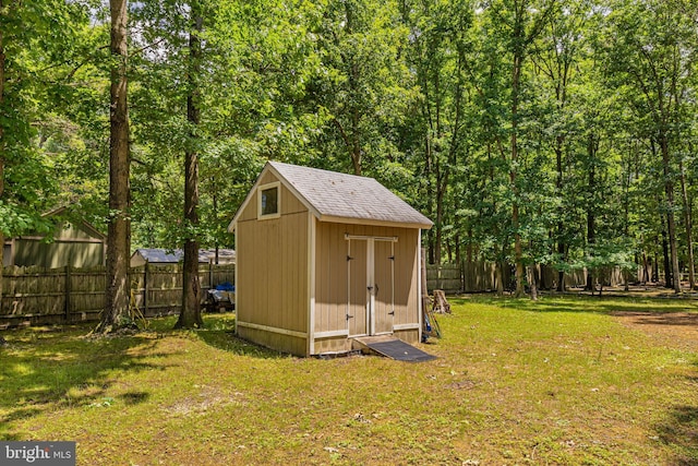 view of shed featuring a fenced backyard and a wooded view