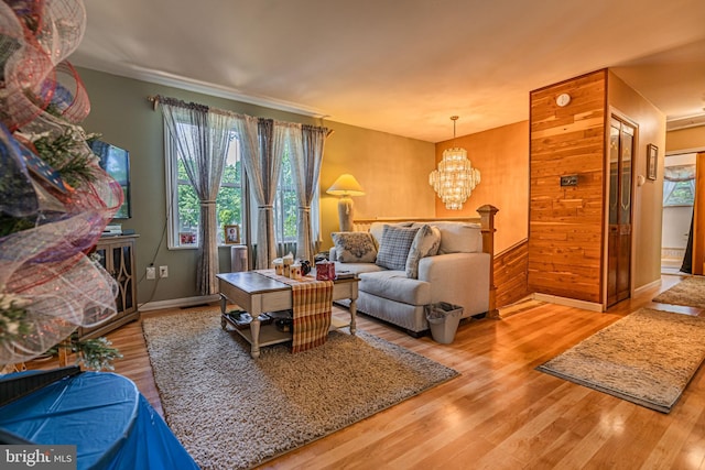 living area with a notable chandelier, baseboards, and wood finished floors