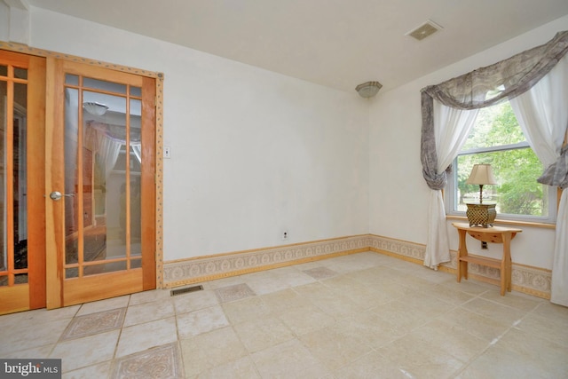 spare room featuring baseboards and visible vents