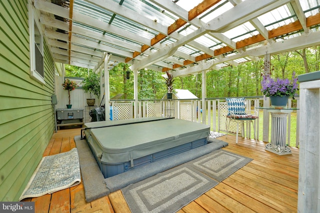 wooden deck featuring a pergola, a covered hot tub, and an outdoor structure