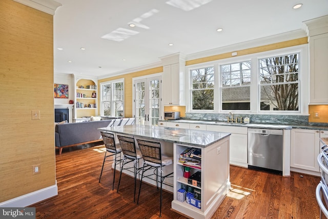 kitchen featuring stone countertops, a kitchen breakfast bar, dishwasher, and white cabinetry