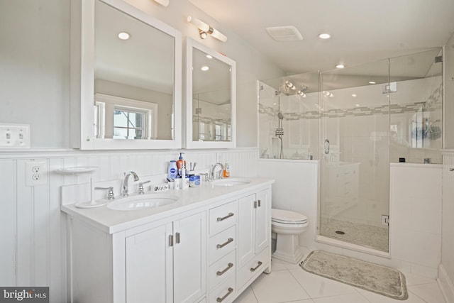 full bathroom with a wainscoted wall, a shower stall, and a sink