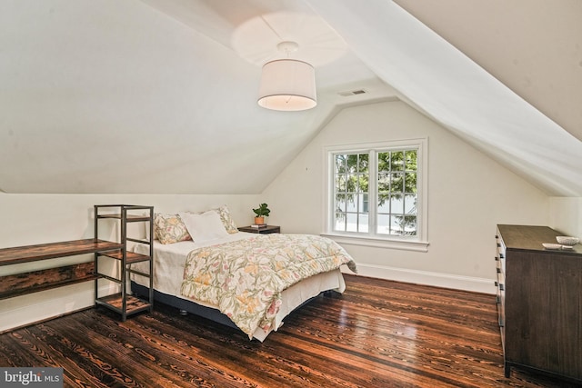 bedroom featuring dark wood-type flooring, visible vents, baseboards, and vaulted ceiling