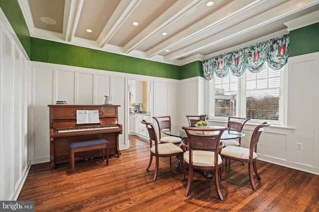 dining area with beam ceiling, a decorative wall, wood finished floors, and ornamental molding