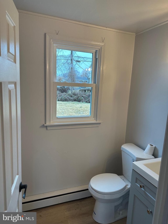 bathroom featuring vanity, hardwood / wood-style flooring, a baseboard radiator, and toilet