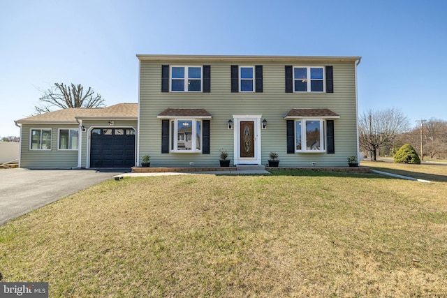 view of front of property featuring driveway, a front lawn, a garage, and a shingled roof
