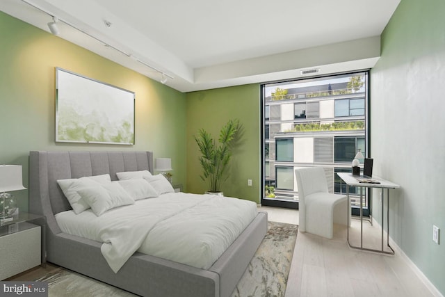 bedroom featuring hardwood / wood-style flooring and rail lighting