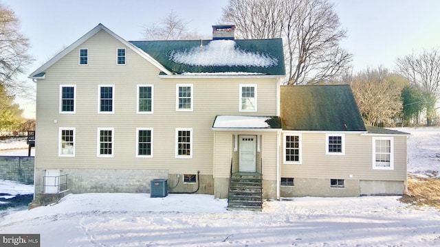 snow covered back of property with central air condition unit