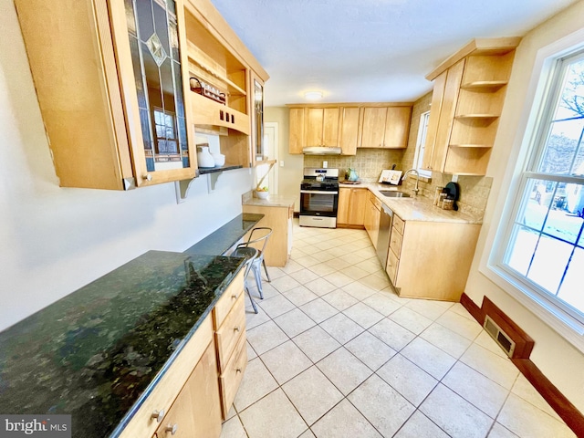 kitchen with light brown cabinetry, sink, light tile patterned floors, stainless steel appliances, and backsplash