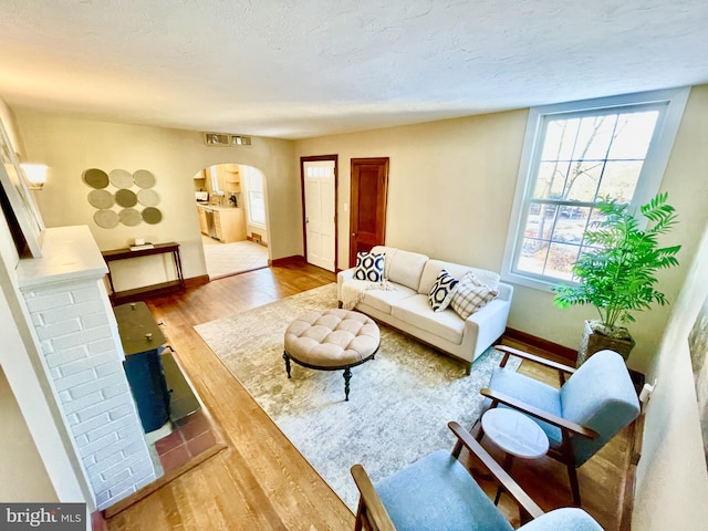 living room featuring wood-type flooring and a textured ceiling