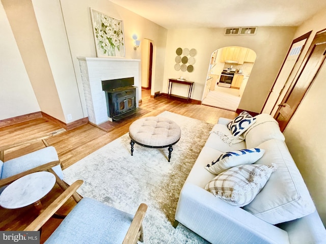 living room with wood-type flooring and a wood stove