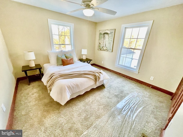 carpeted bedroom with multiple windows and ceiling fan