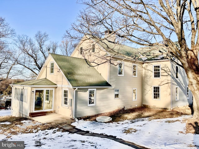 view of snow covered rear of property