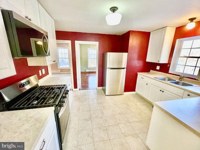 kitchen featuring a healthy amount of sunlight, sink, white cabinets, and appliances with stainless steel finishes