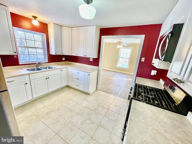 kitchen featuring white cabinetry, sink, light tile patterned floors, and a wealth of natural light