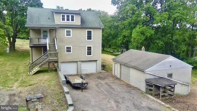 back of property featuring a garage, covered porch, and a lawn