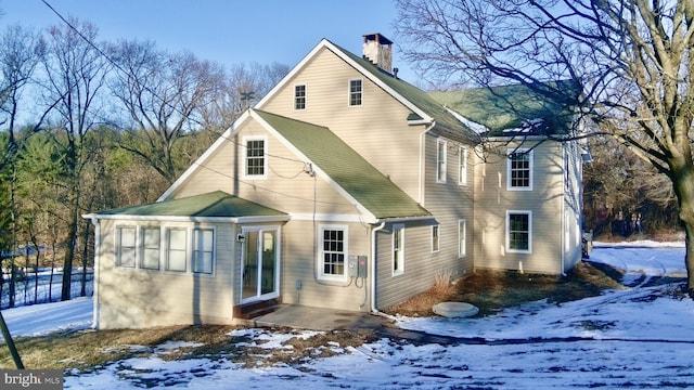 view of snow covered back of property