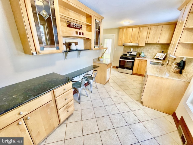 kitchen with light brown cabinetry, sink, light tile patterned floors, stainless steel stove, and backsplash