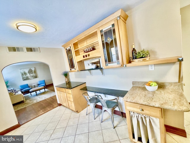 kitchen with light tile patterned floors and light brown cabinets