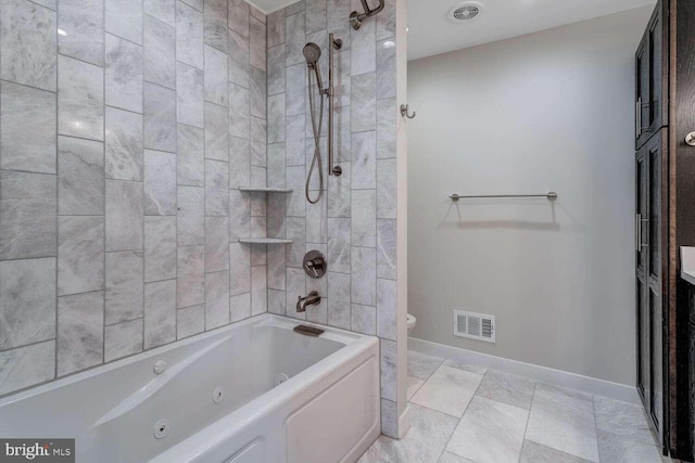 bathroom featuring toilet and tiled shower / bath combo