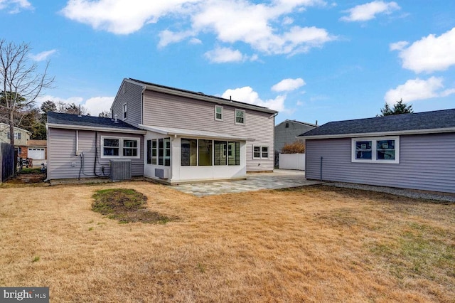 rear view of house with cooling unit, a patio area, and a lawn