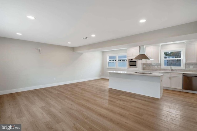 kitchen with a kitchen island, exhaust hood, white cabinets, and appliances with stainless steel finishes