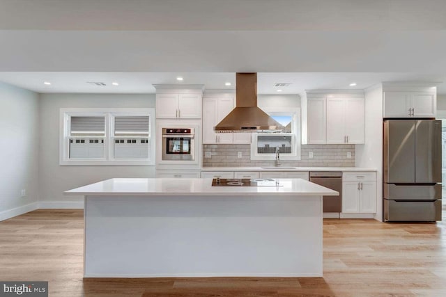 kitchen featuring white cabinetry, sink, island range hood, and stainless steel appliances